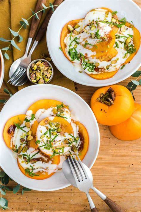 Karamellisierte Kaki mit Minz-Joghurt und Pistazien auf Teller