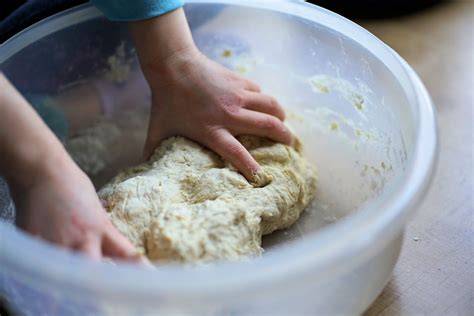 Kind knetet Teig für Apfelkuchen im Kindergarten