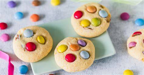 Kinder backen Smarties-Kekse zusammen in der Küche