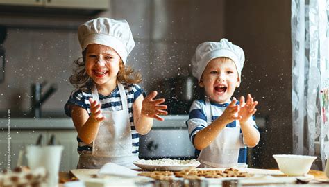 Kinder beim Backen, Keksformen und Zutaten auf dem Tisch