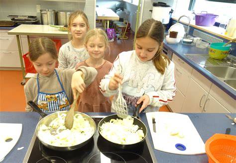 Kinder beim Marmeladekochen am Herd