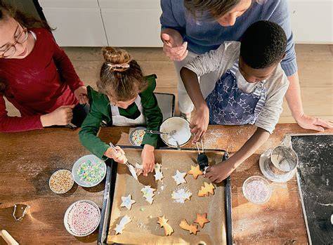 Kinder beim gemeinsamen Plätzchenbacken und Verzieren