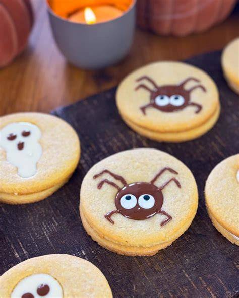 Kinder dekorieren Halloween-Kekse am Tisch