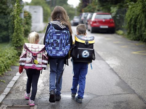 Kinder gehen bei Regen zur Schule (symbolbild)
