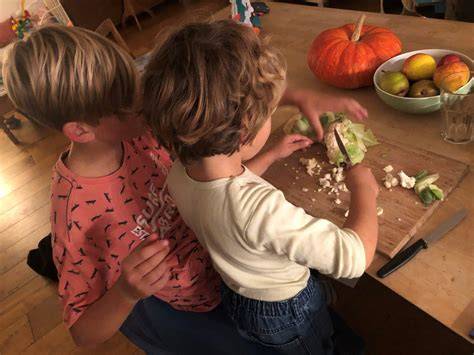 Kinder helfen beim Apfelschälen für Apfelkuchen