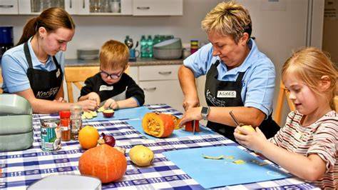 Kinder helfen beim Zubereiten von Karotten und Kartoffeln in der Küche