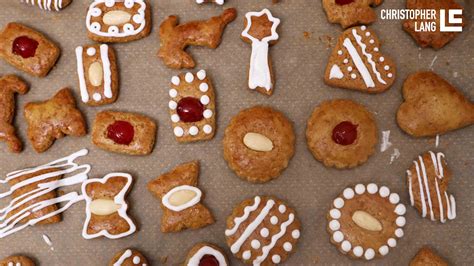 Kinder verzieren gemeinsam Lebkuchen mit buntem Zuckerguss und Streuseln
