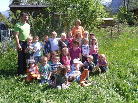 Kindergartenkinder mit Imker beim Honigernten