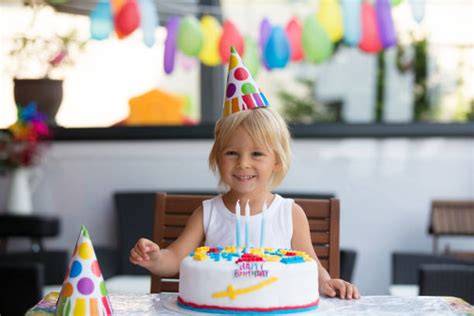 Kindergeburtstag: Glückliches Kind mit dreistöckigem Tortentraum