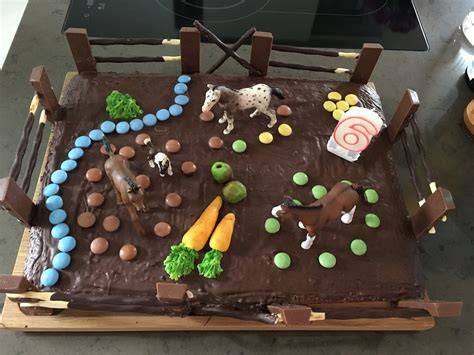 Kindergeburtstag: Pferdekuchen mit Schokoladenzaun, Figuren und essbaren Blumen dekoriert