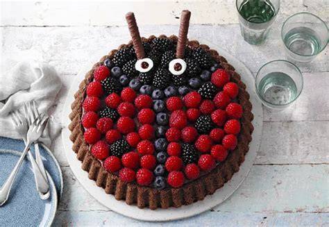 Kindergeburtstagstisch mit Marienkäfer Torte und bunten Tellern