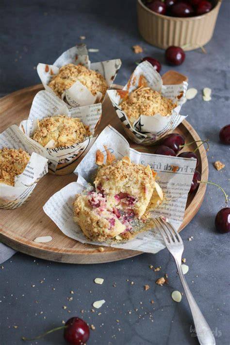 Kirsch-Streusel-Muffins auf rustikalem Brett, Nahaufnahme der Streusel und saftigen Kirschstücke