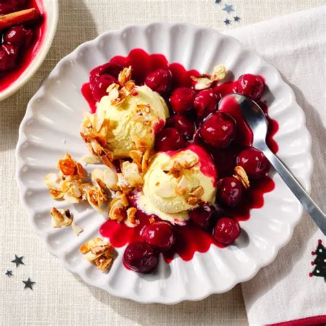 Kirschkuchenstücke mit Vanilleeis und frischen Kirschen serviert