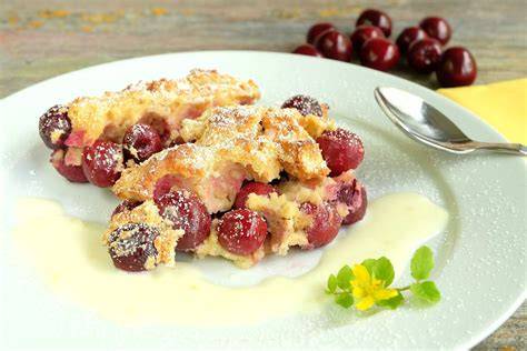 Kirschmichel mit Puderzucker und Vanillesoße angerichtet