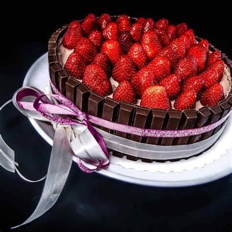 KitKat Torte mit Erdbeeren, Schokolinsen und Schleife als Geschenk verziert