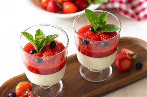 Klassisch servierte Panna Cotta mit Erdbeersoße und Minze