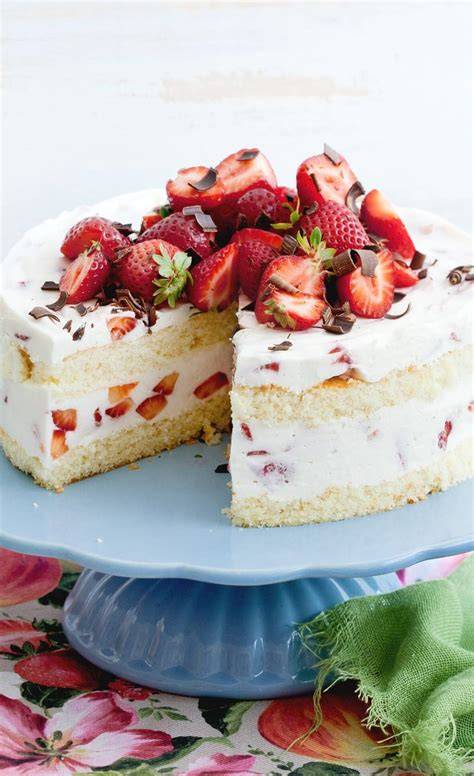 Klassische Kuppeltorte auf einer Tortenplatte, angeschnitten, mit Erdbeerdekoration