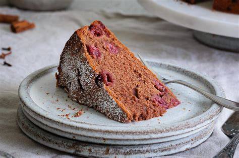 Klassischer Gewürzkuchen mit Kirschen angeschnitten auf einem Holztisch