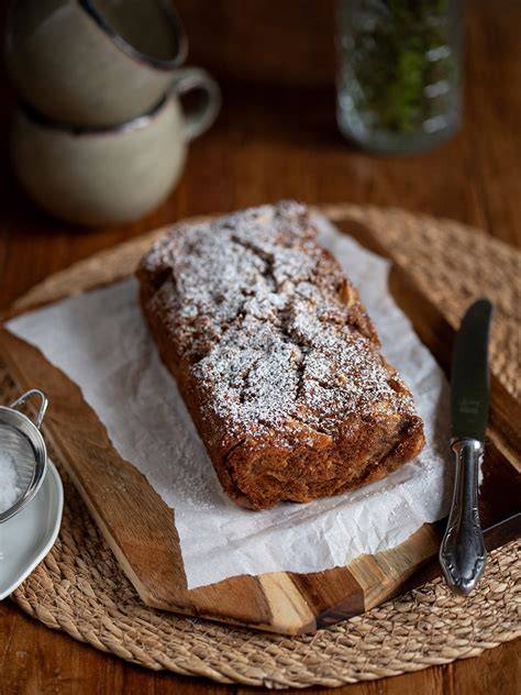 Kleiner Kastenrührkuchen auf einem Backgitter, mit Puderzucker bestäubt