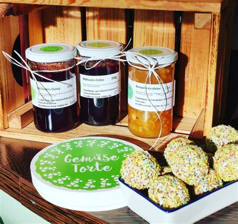 Kleines Schälchen Marmelade, Kokossirup-Fläschchen und Kokosraspel als Geschmacksnote