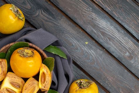 Knallorange Kakis auf Holztisch