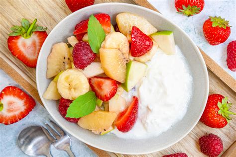 Knuspriges Brot, Joghurt, frisches Obst und Honig auf Frühstückstisch
