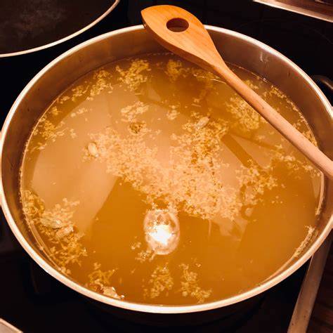 Kochender Apfelsaft im großen Topf, langsam einkochend
