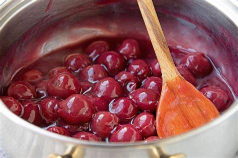Kochendes Kirschkompott im Topf, mit Marshmallowkirschen und Saft