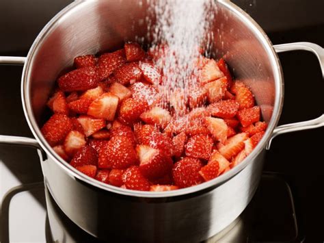 Kochtopf mit sprudelnder Erdbeermarmelade und Schaumabschöpfen