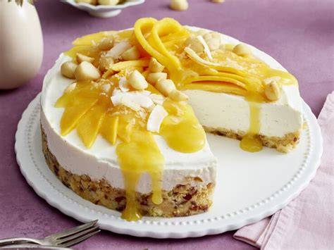 Kokos Macadamia Torte auf tropischem Hintergrund, angeschnitten