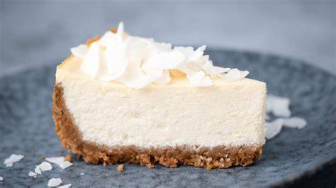 Kokos-Käsekuchen auf Teller mit Kokosraspeln