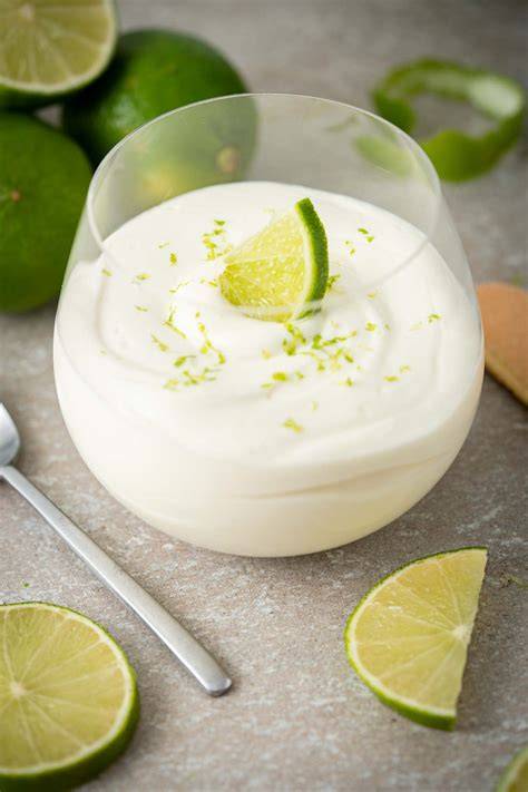 Kokosflocken mit zerbröselten Butterkeksen als Topping für Limetten-Mousse im Glas