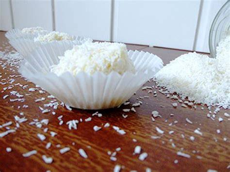 Kokospralinen mit weißer Schokolade auf Papierförmchen