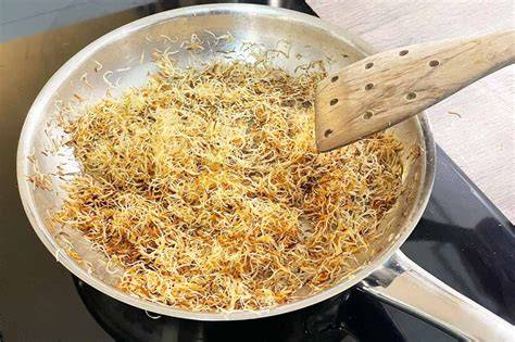 Kokosraspel in der Pfanne goldbraun angebraten