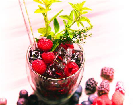 Kombination aus Beeren und Kräutern in Eiswürfeln