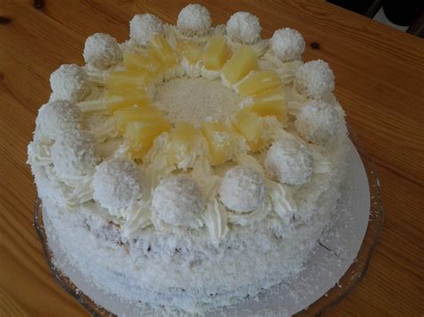 Komplett aufgebaute und dekorierte Raffaello-Ananas-Torte auf einer Tortenplatte