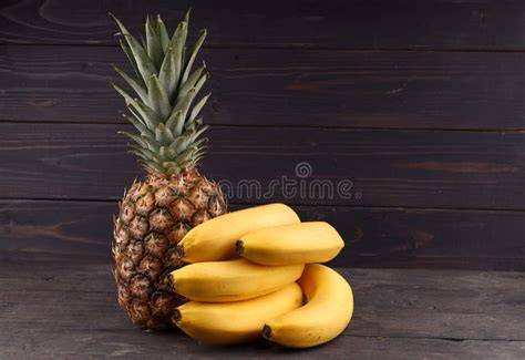 Konfitürengläser, Bananen und Ananas auf einem rustikalen Tisch