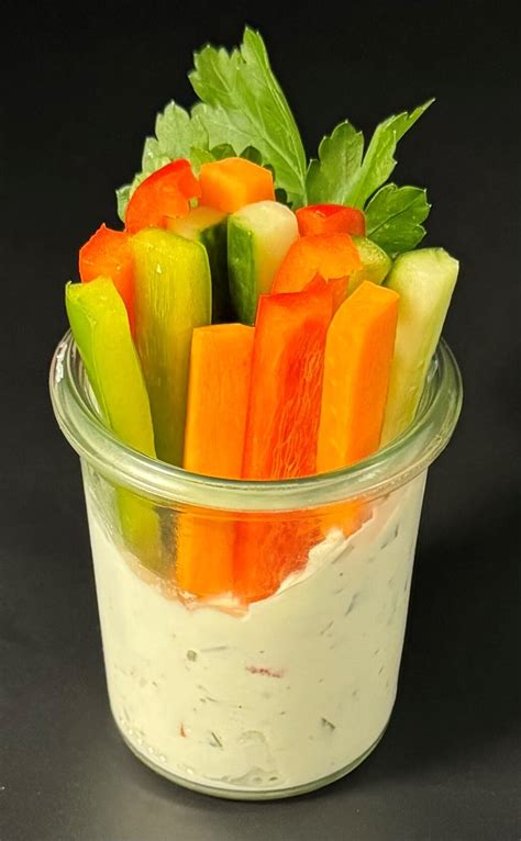 Kräuterquark im Glas mit frischem Brot und Gemüsesticks