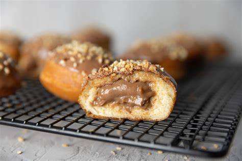 Krapfen mit Nougatfüllung auf einem Teller, dekoriert mit Puderzucker