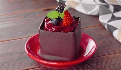 Kreatives Dessert mit Gemüse und Schokolade auf Porzellanteller