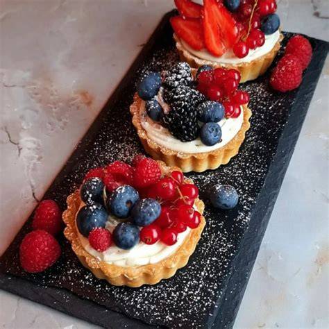 Krumkaker mit Vanillecreme und Beeren angerichtet
