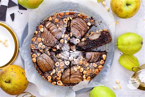 Kuchen mit Äpfeln, Birnen, Kürbis und Nüssen auf einer Holztafel