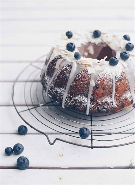 Kuchen mit Limettenzuckerguss und Blaubeeren dekoriert