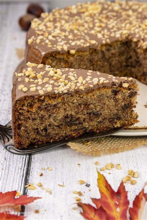 Kuchen mit geschmolzener Schokoladenglasur und gehackten Haselnüssen dekorieren
