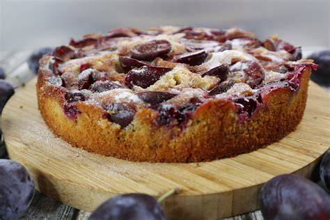 Kuchen vor dem Backen mit dekorierten Zwetschgen und Apfelspalten