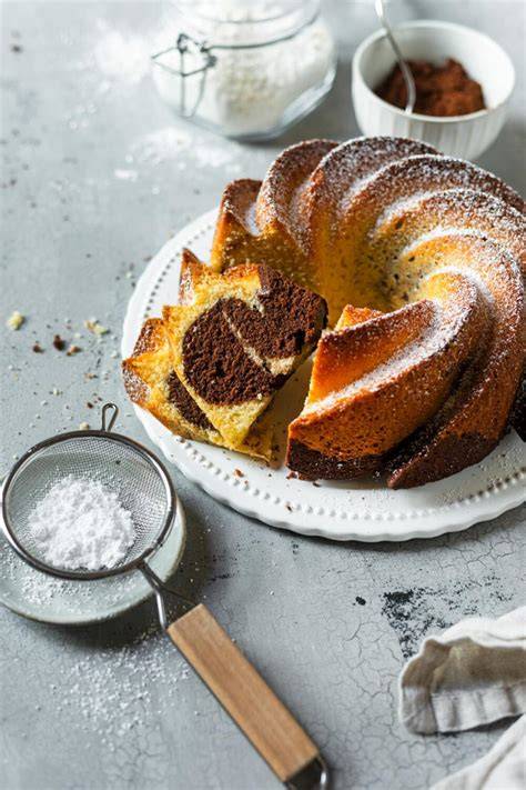 Kuchenplatte mit mehreren Scheiben Marmorkuchen und Puderzucker