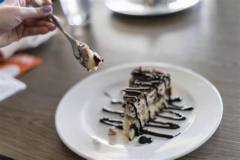 Kuchenscheibe auf einem Teller mit einer Gabel und einer Portion Vanilleeis daneben