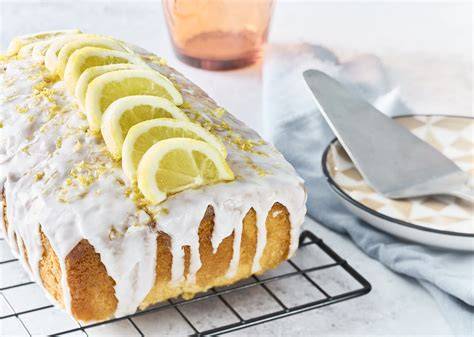 Kuchenstück mit Kokosflocken und Zitronen garniert auf einem Kuchengitter