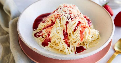Kuchenstück mit Spaghetti Eis Effekt, Erdbeersoße und weißer Schokolade garniert