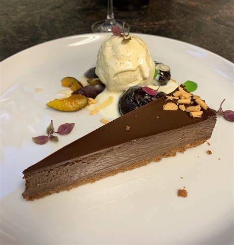 Kuchenstücke mit Zwetschgen, Nüssen und Schokolade, garniert mit Vanilleeis